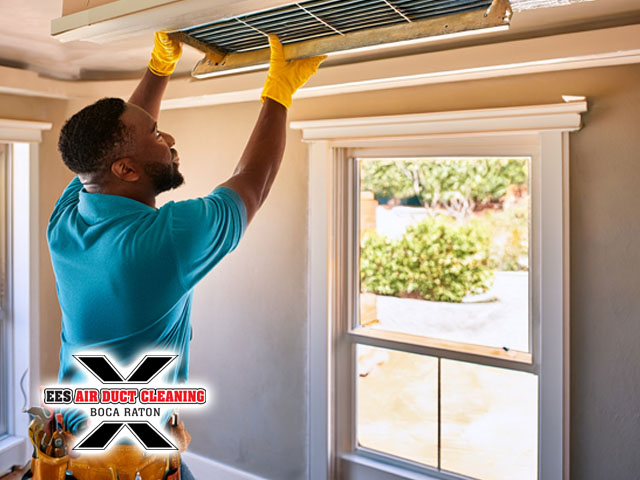 professional technician working on cleaning air duct ceiling vent interior of boca raton florida residential home
